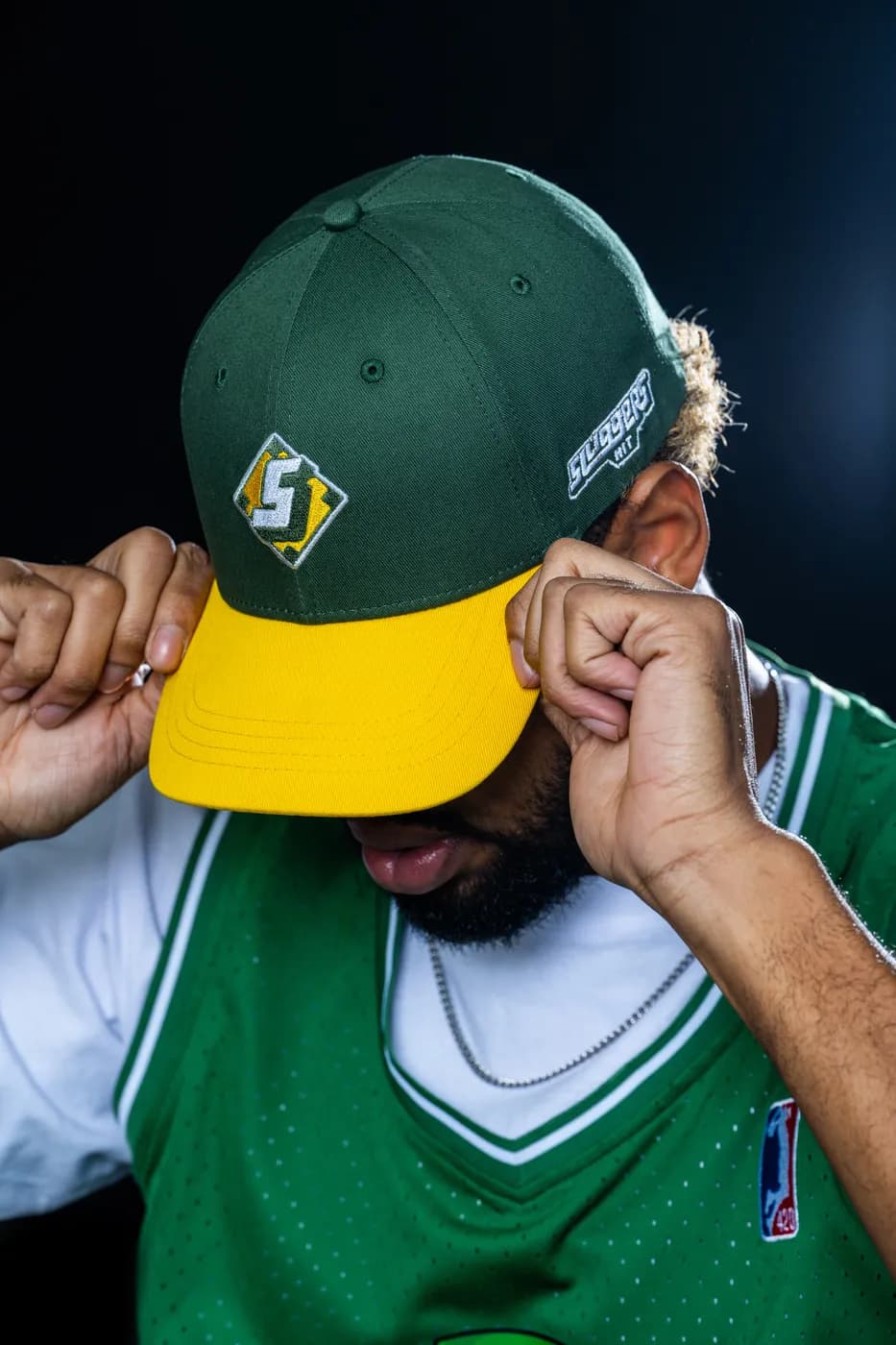 The Ballpark Snapback, a two tone green crown with a gold flat brim.
