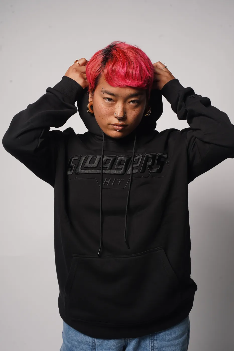 The Blackout Hoodie in close-up, the wordmark raised in the same black as the fleece.